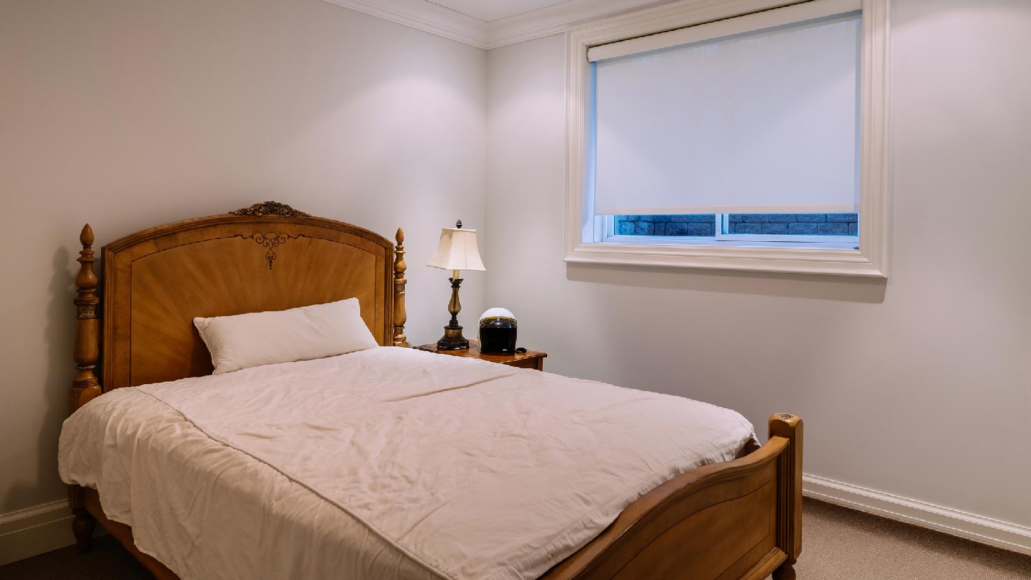 A basement bedroom with a vintage wooden bed