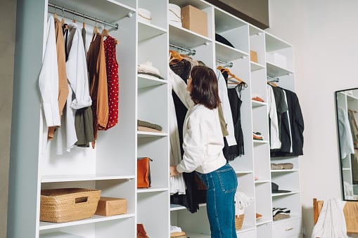 Woman hanging clothes in a walk-in-closet