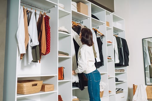  Woman hanging clothes in a walk-in-closet