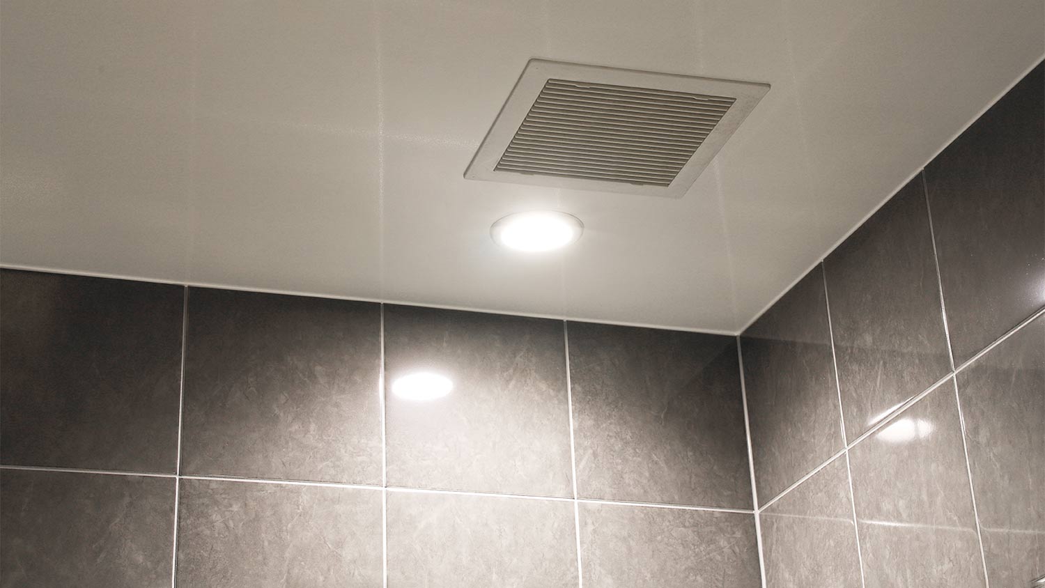 A ceiling fan in a tiled bathroom
