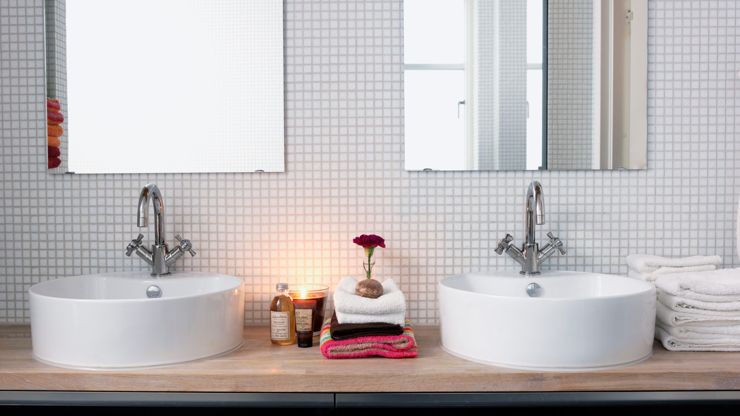 A bright bathroom with double sinks and white tiles
