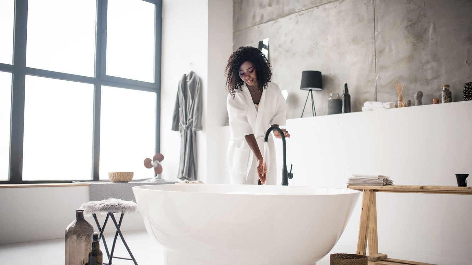 woman filling large tub in a luxury bathroom