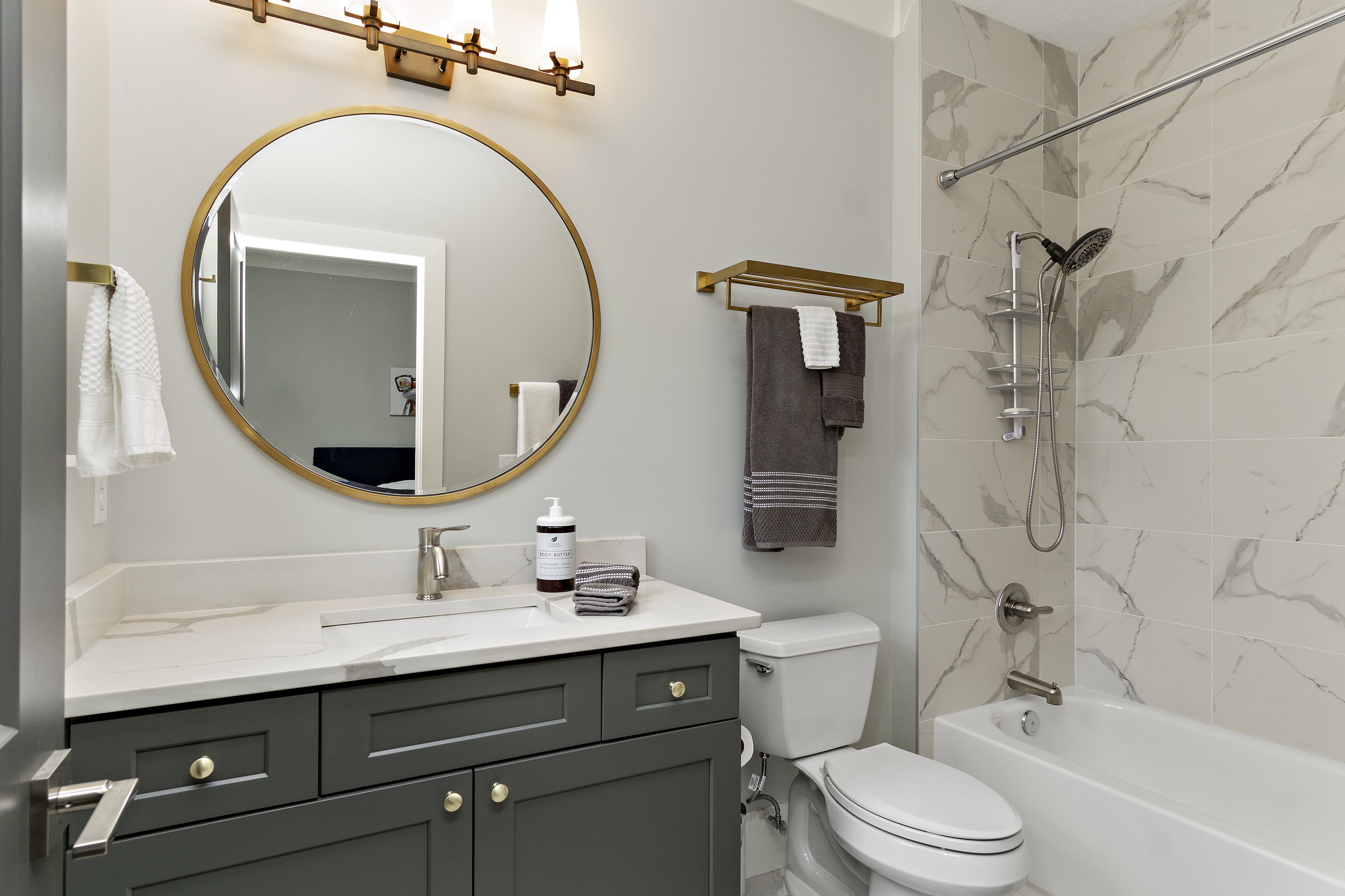 Modern bathroom with brass circular mirror