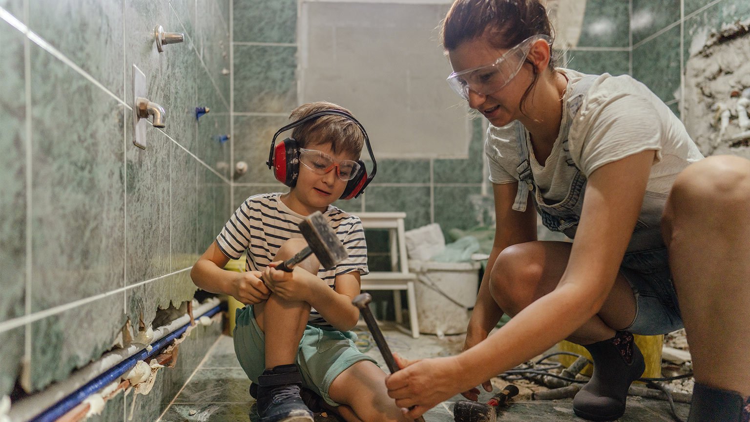 Mother and her young son doing a bathroom remodel project together