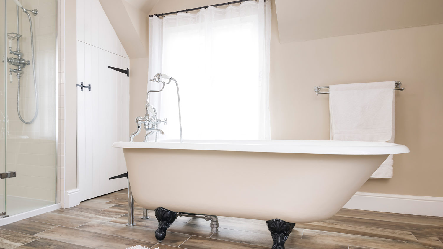 bathroom with white sheer curtains and white clawfoot tub