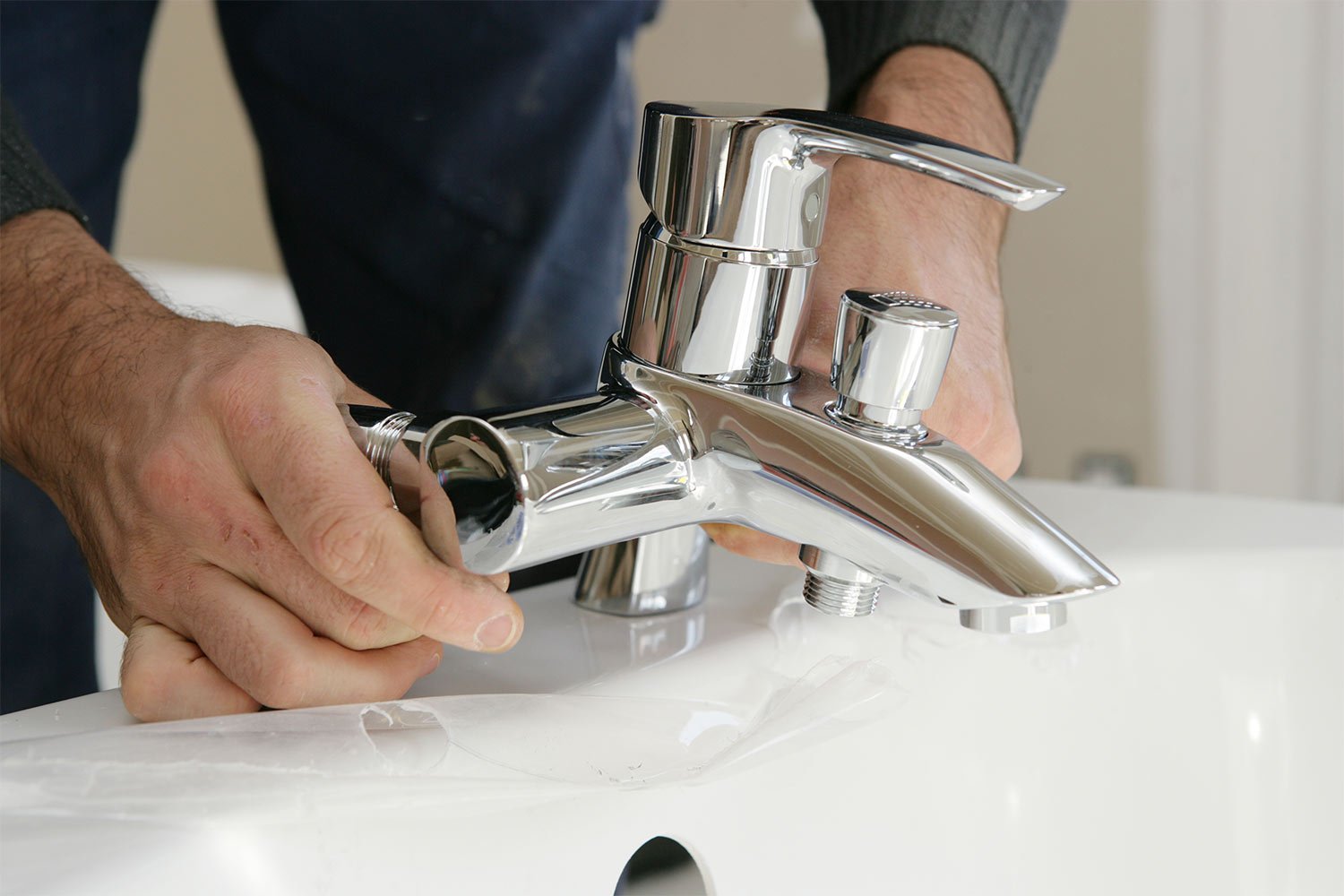 Man installing bathtub hardware