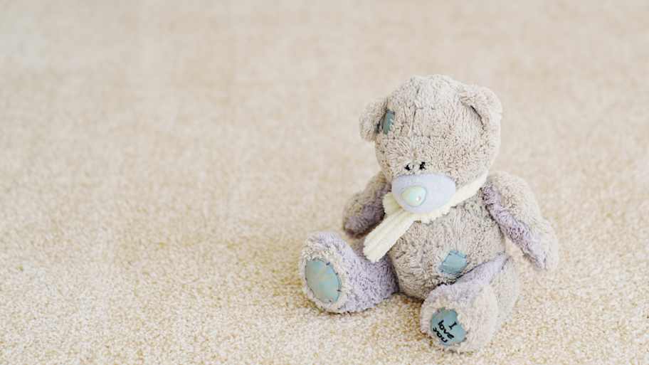Close-up. teddy bear on the beige Interior pile carpet made of polypropylene
