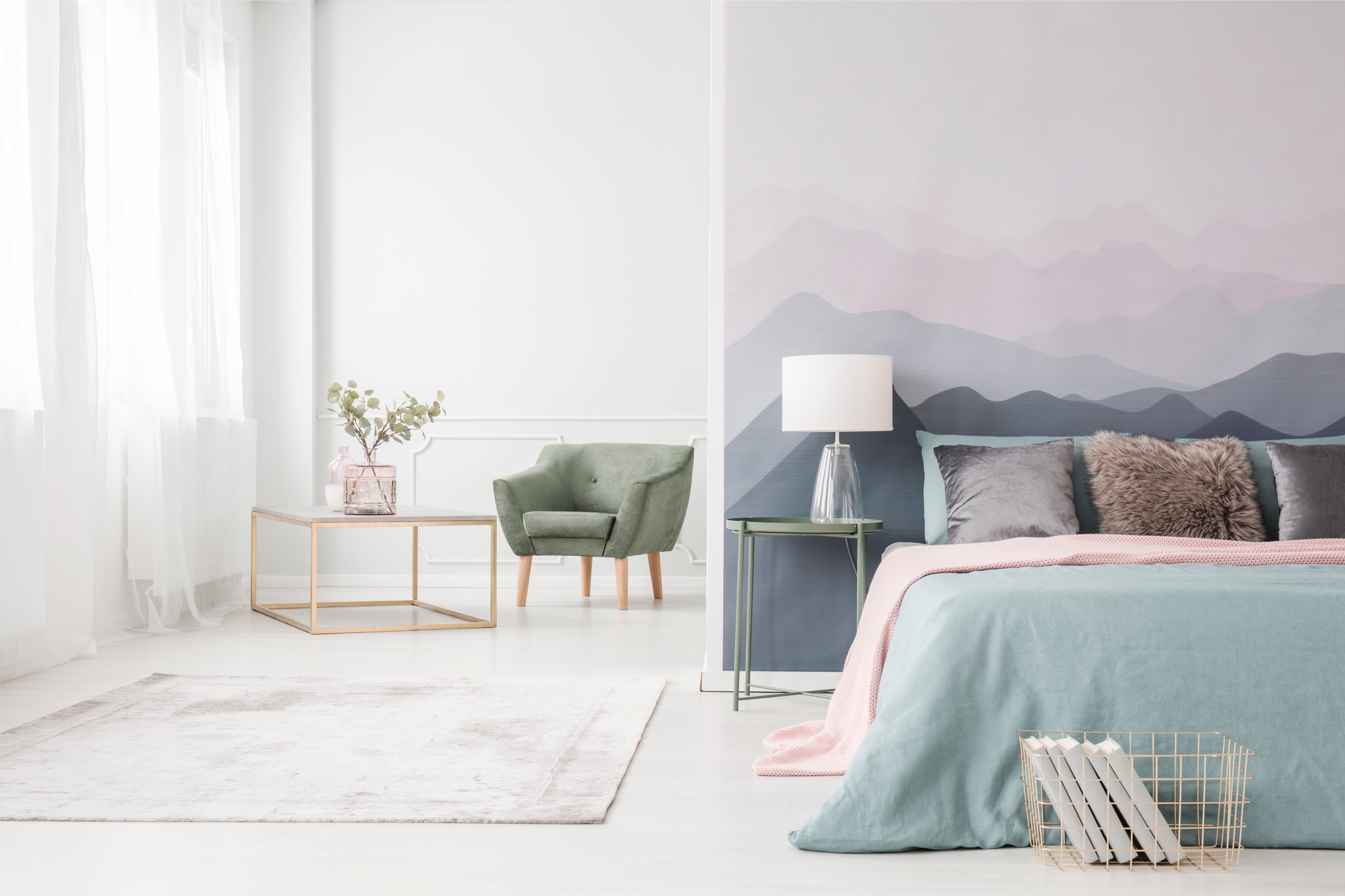 Modern bedroom with bed, nightstand, lamp, and mountain mural wallpaper