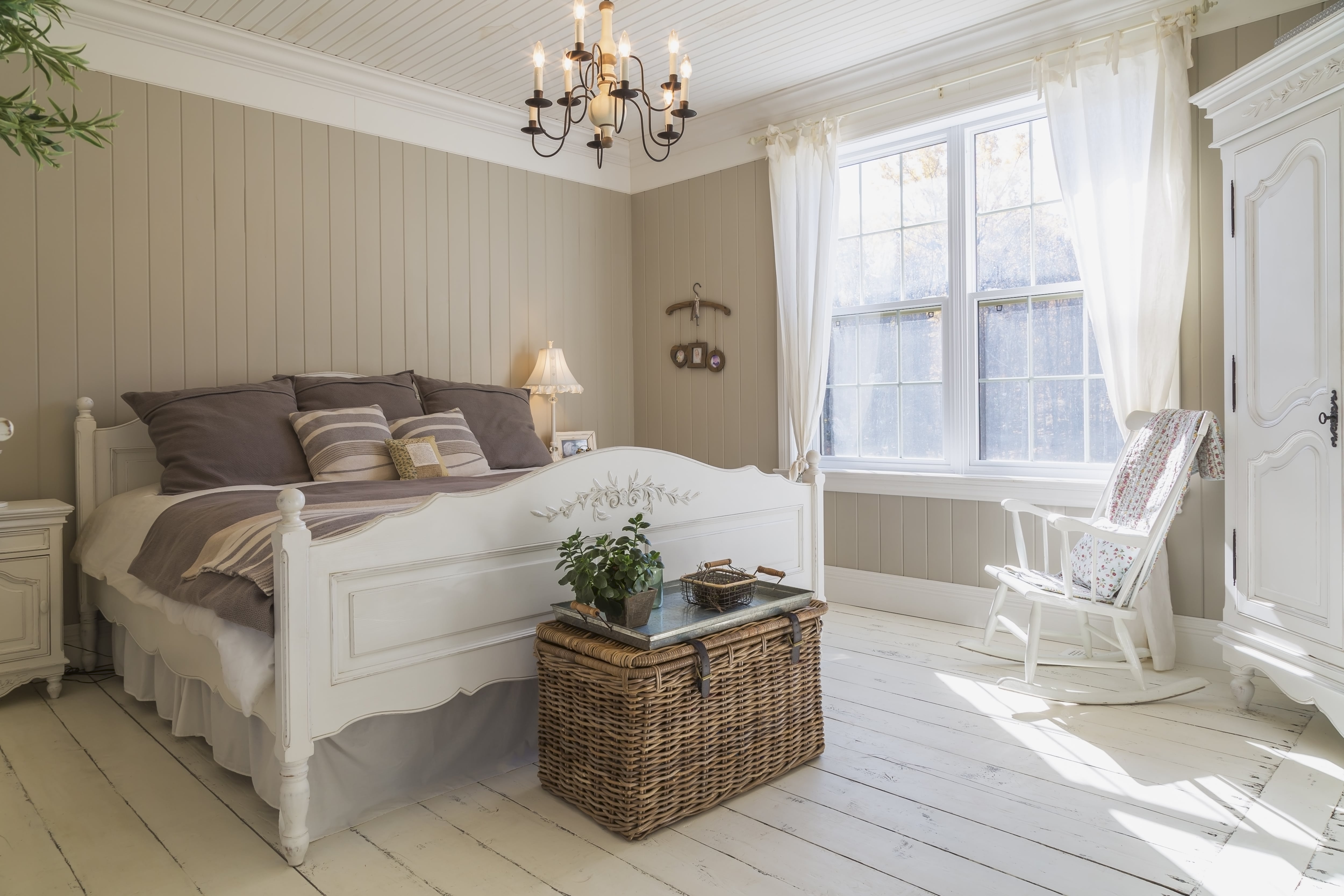 Cozy, rustic farmhouse bedroom with antique furniture and window