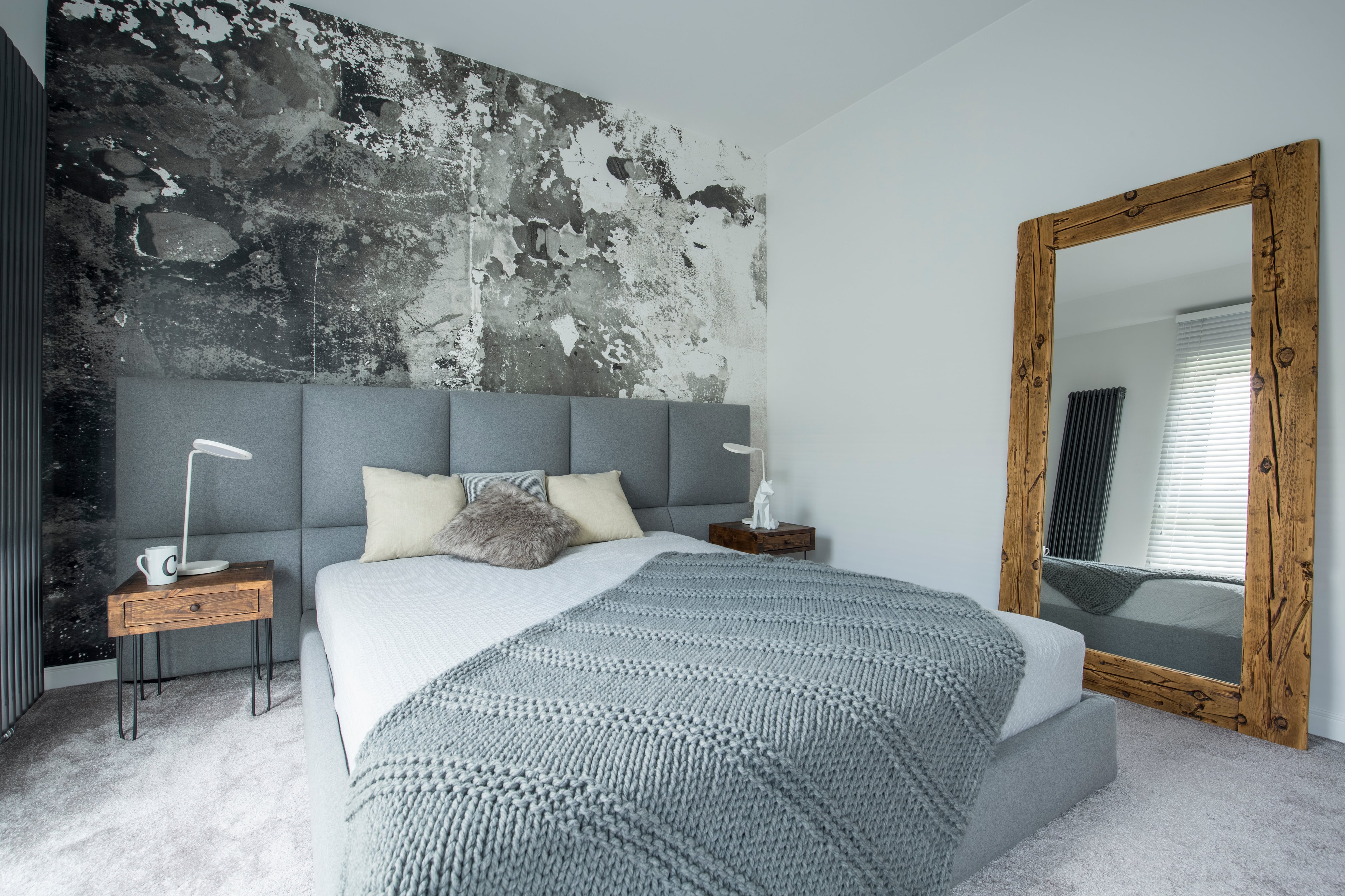 Gray bedroom with painted accent wall and wood-framed standing mirror