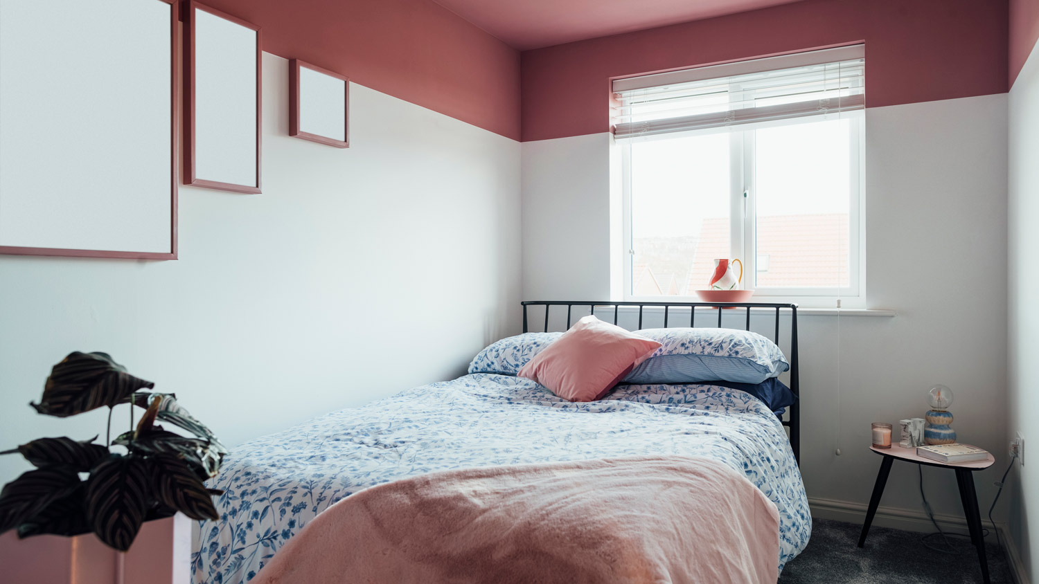 A bedroom with white walls and pink ceiling