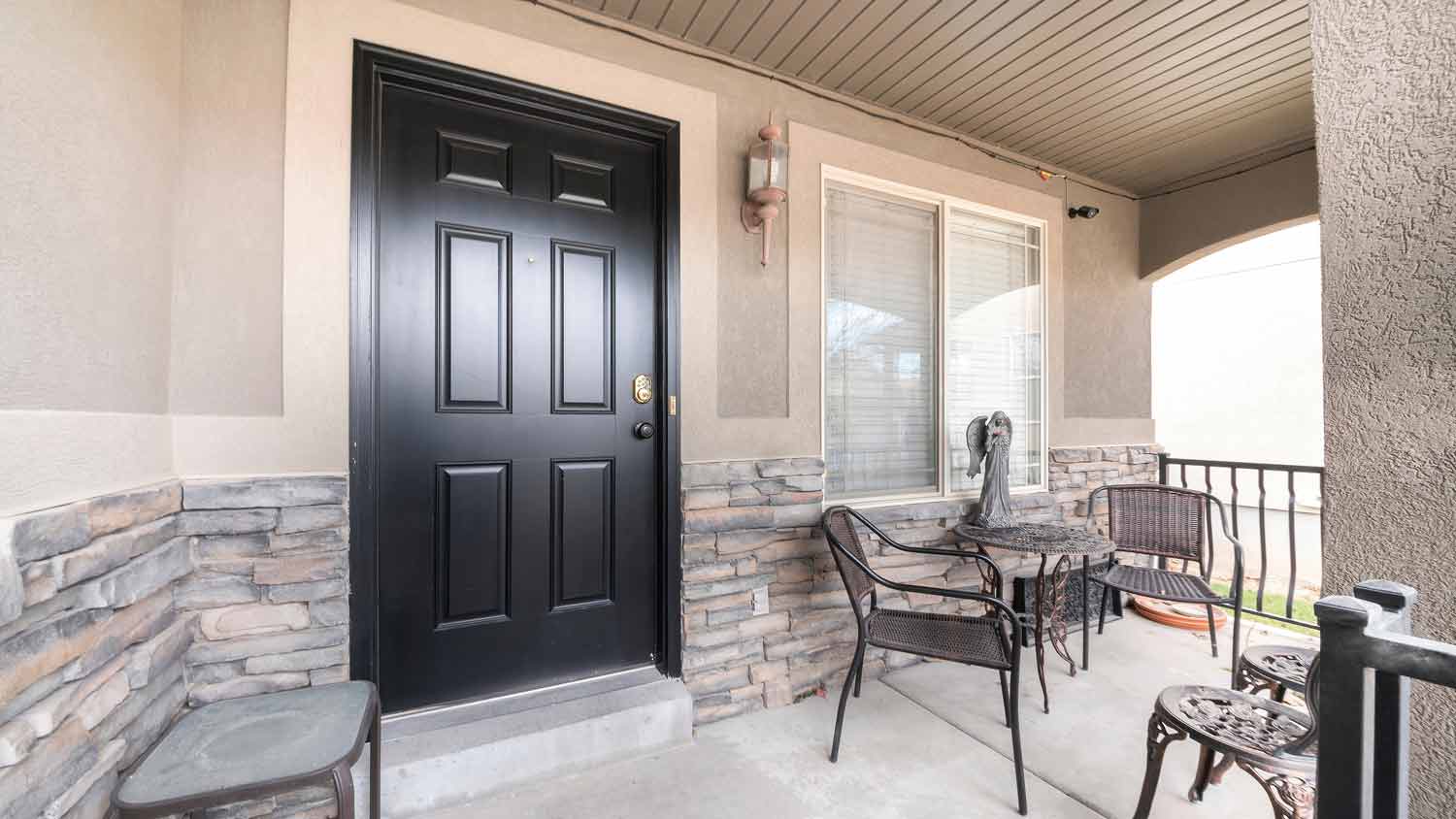  beige front porch with black door 