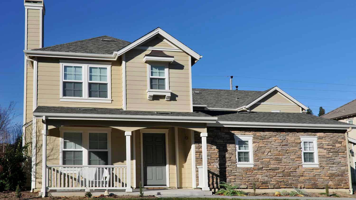 beige two story home with grey roof