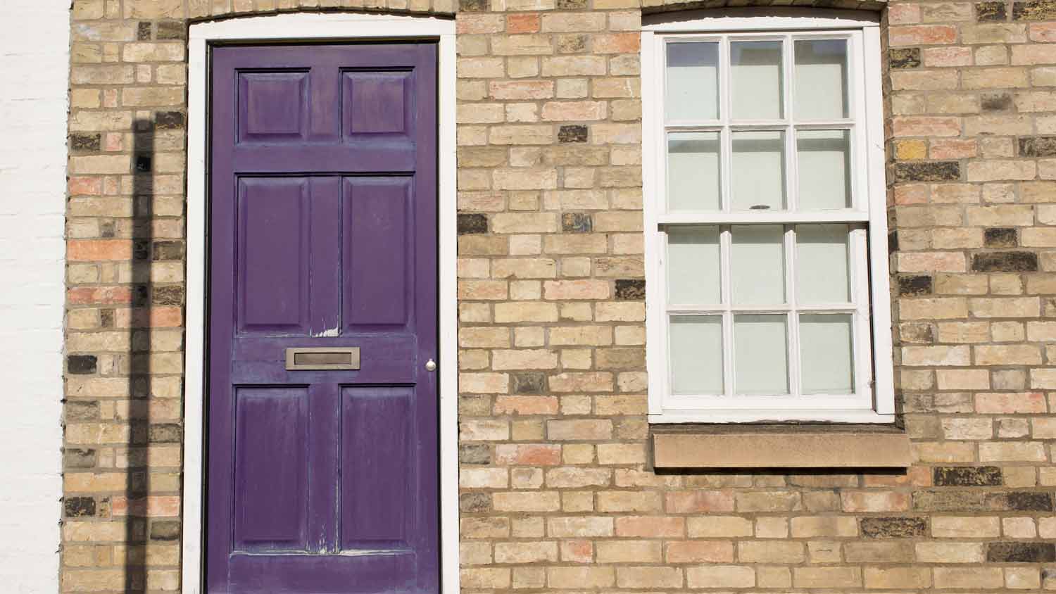 beige home with purple door