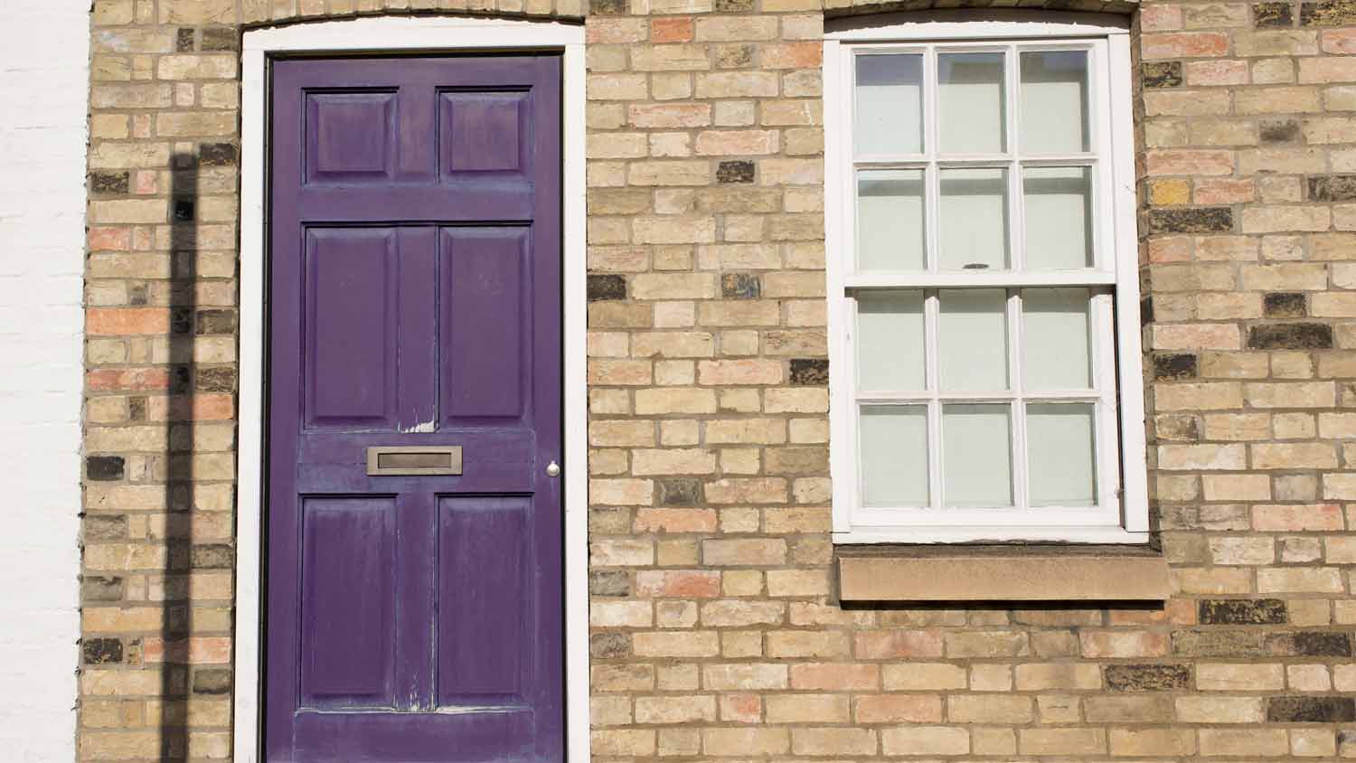 beige home with purple door 