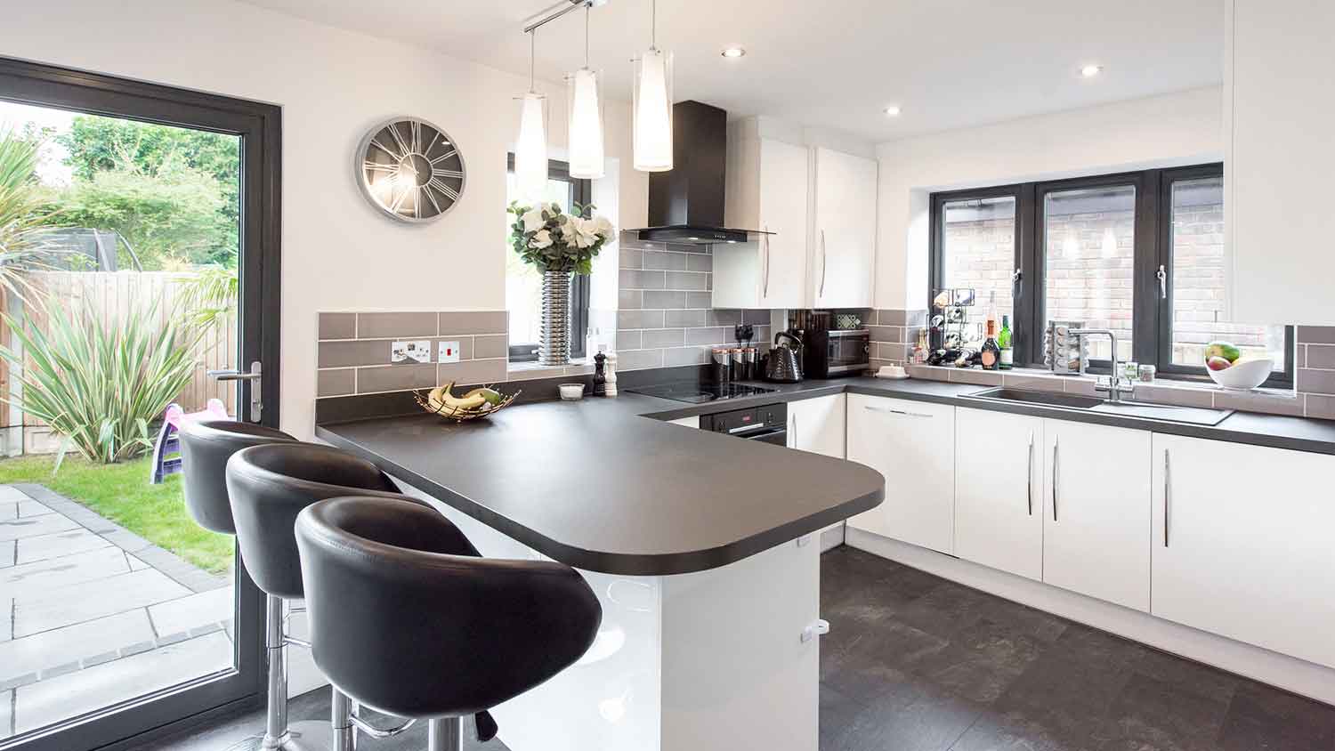 Kitchen with black countertop and white cabinets