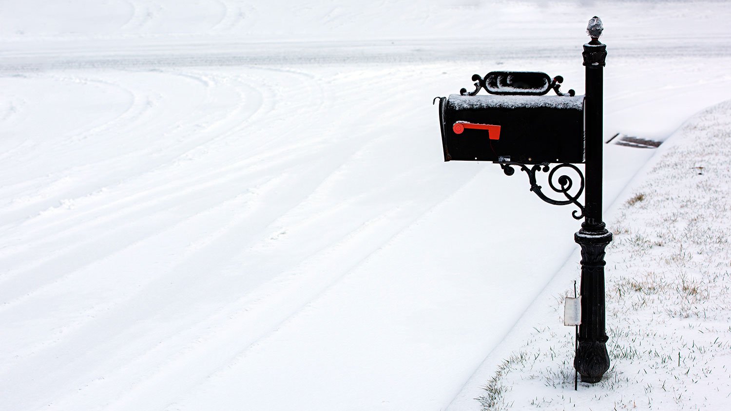 Black metal mailbox in the snow