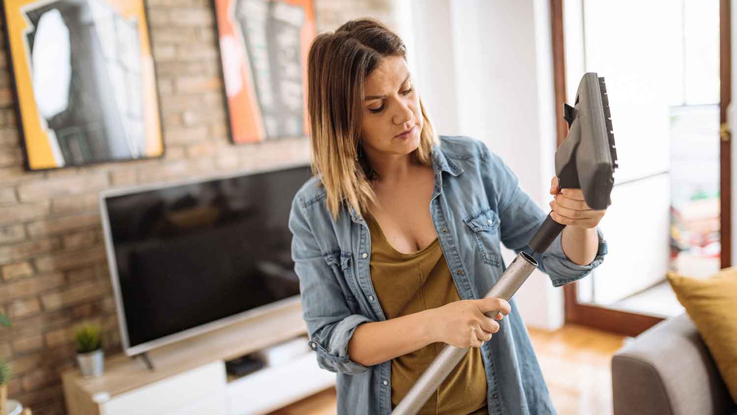 Woman inspecting vacuum cleaner hose