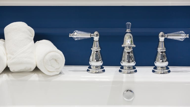 Bathroom sink against blue wall with folded towels