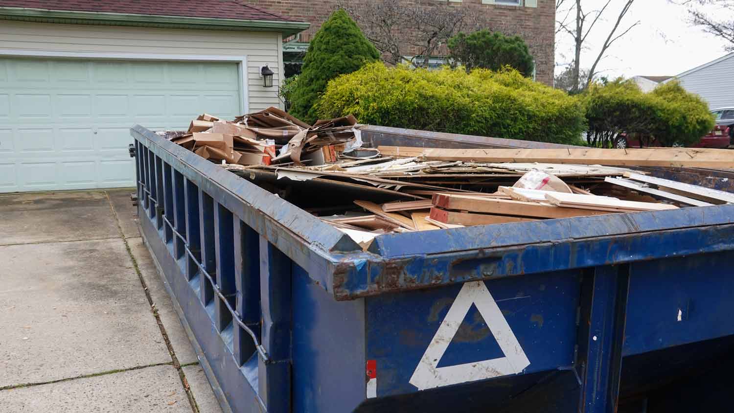 long blue dumpster outside home