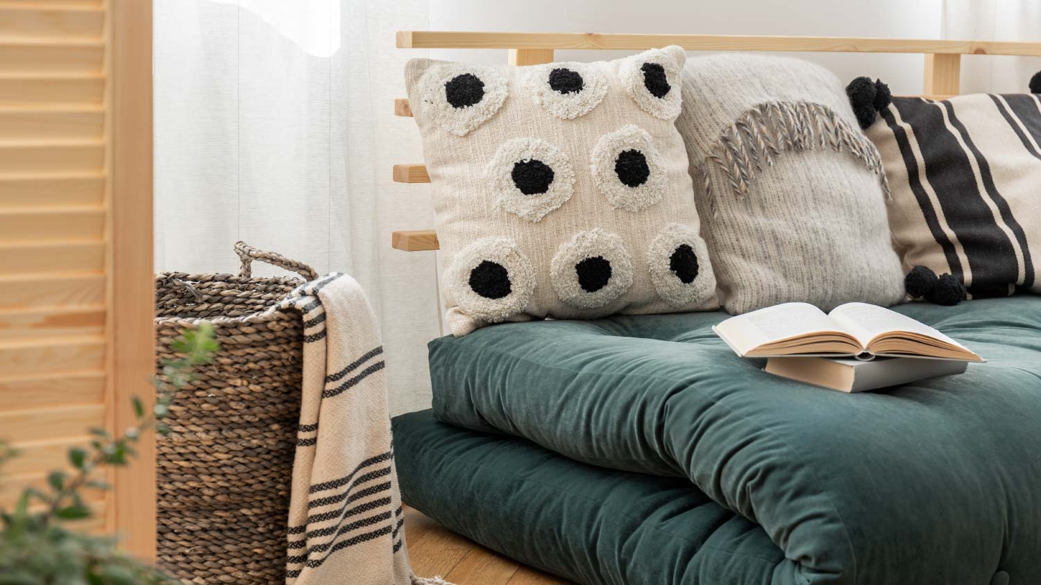 blue futon with pillows on wood floor