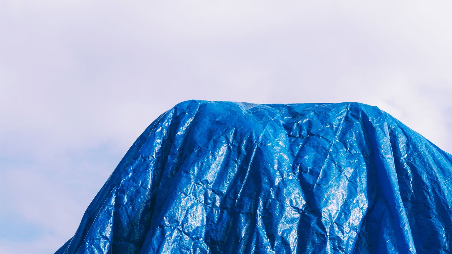 A view of a blue tarp against the sky