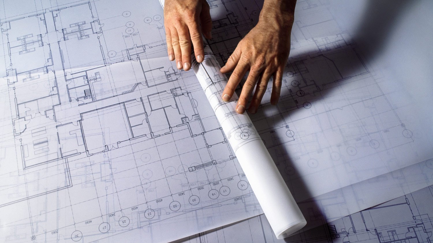 Man unrolling architectural plans, close-up