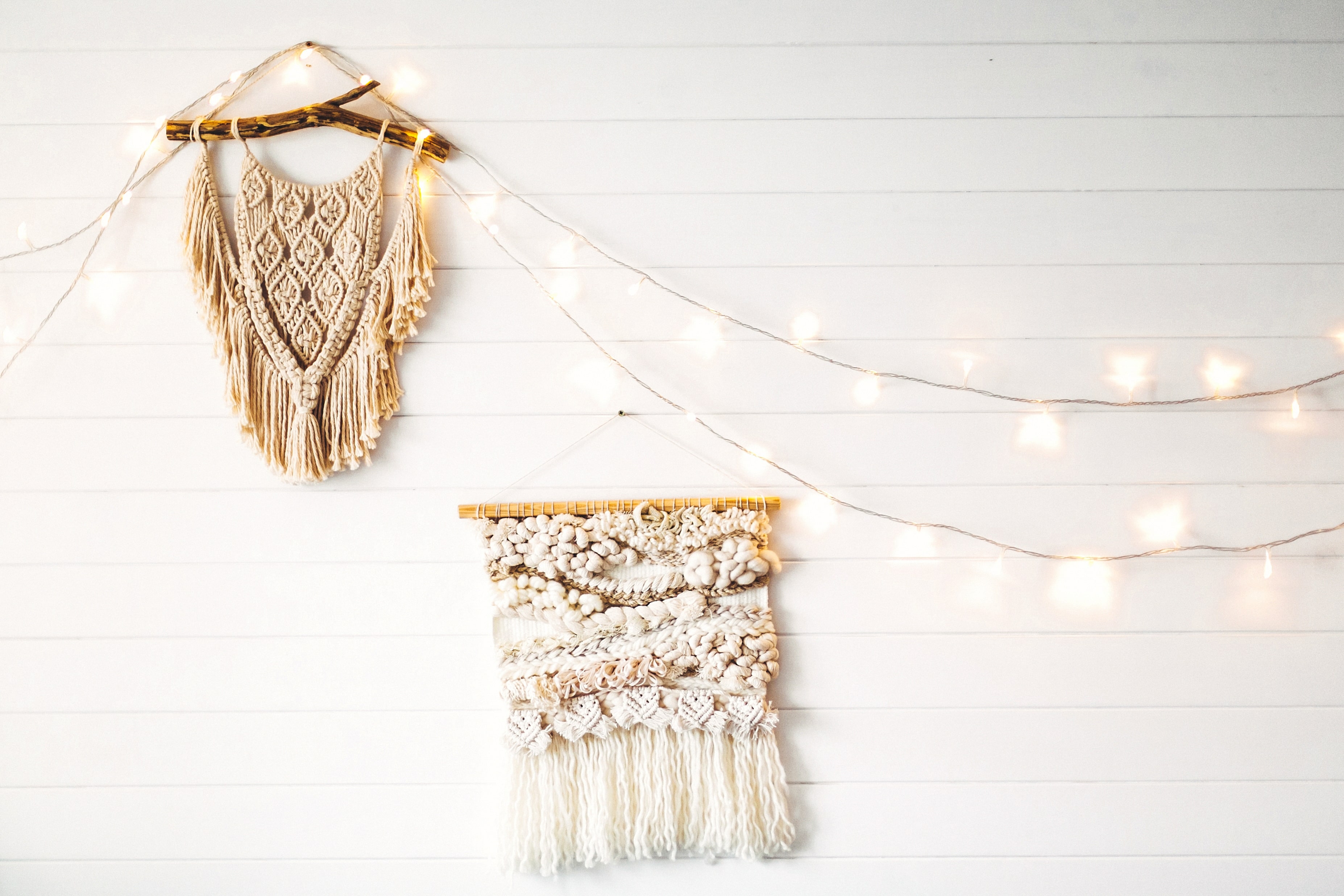 Macrame and string lights hanging on white shiplap wall