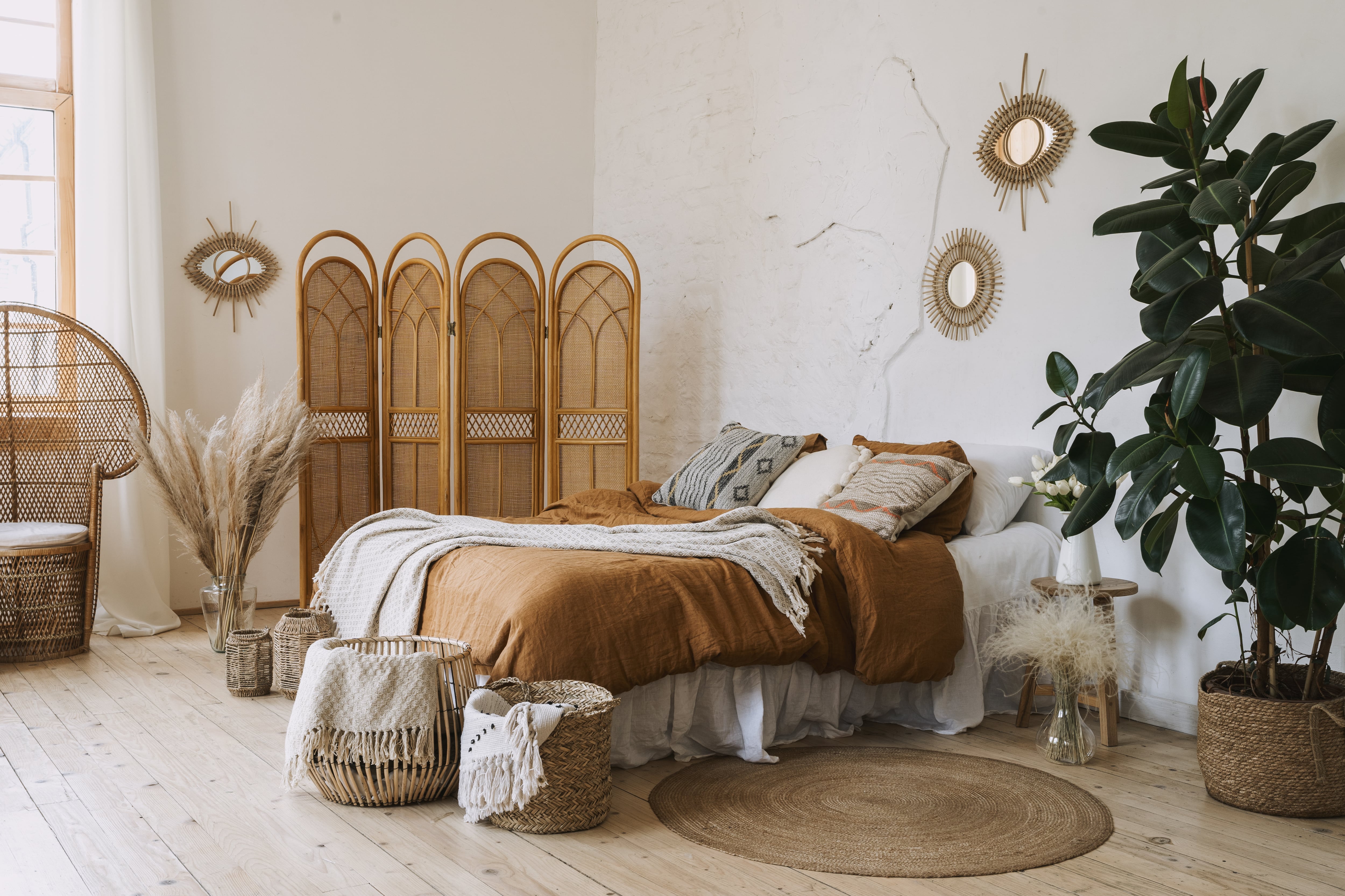 Bohemian-styled bedroom with room divider and woven baskets