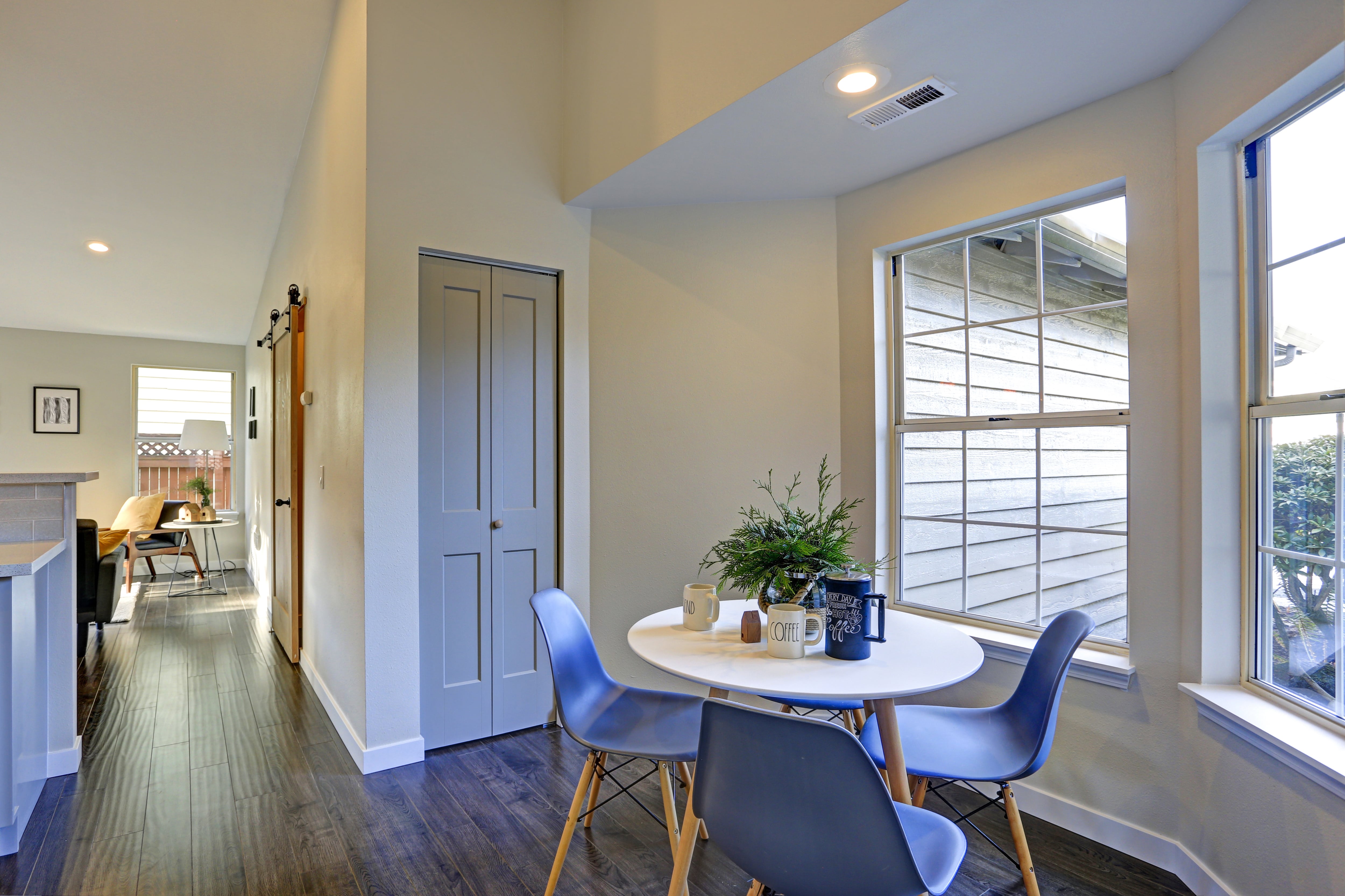 A remodeled kitchen area with a small table by a bay window