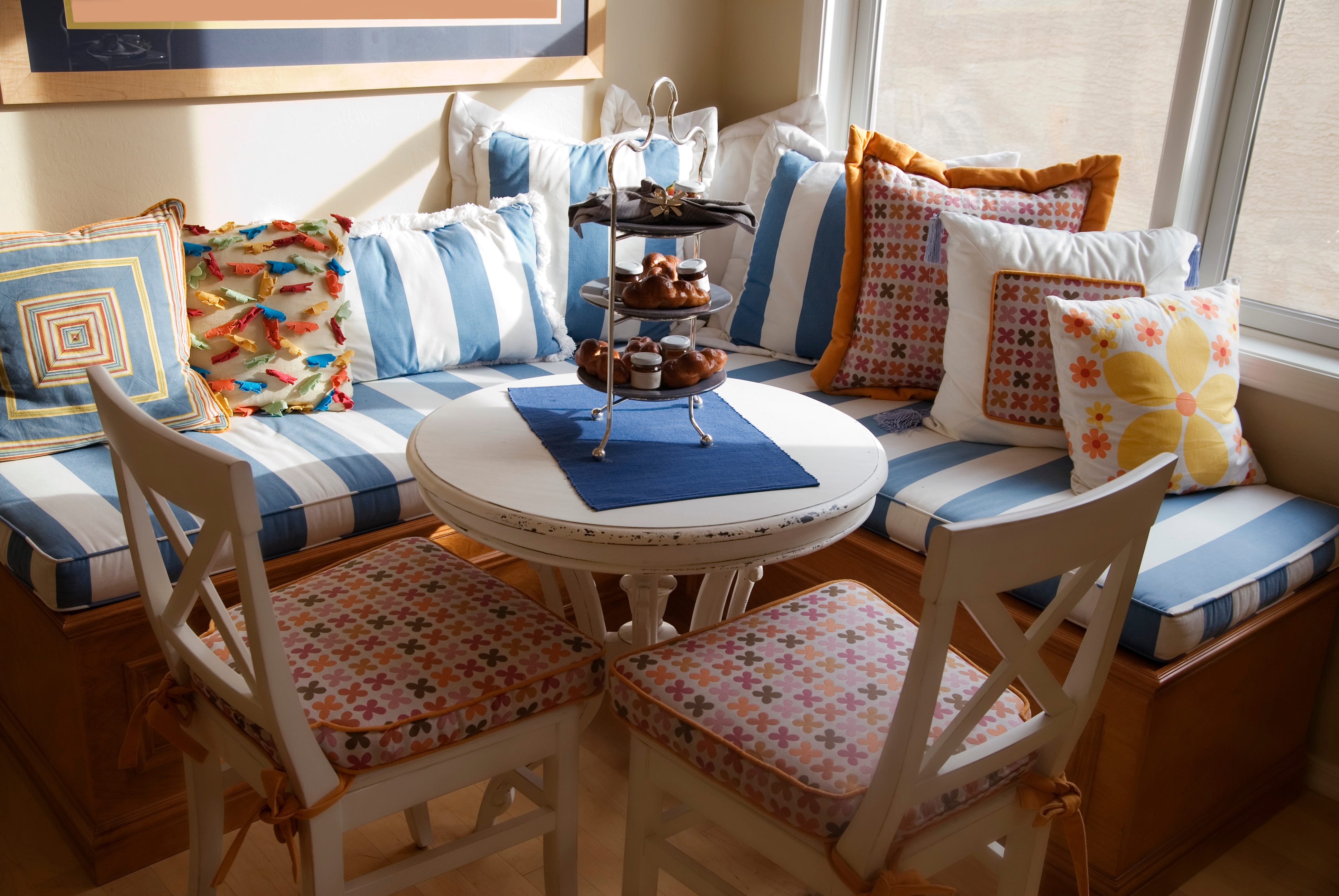 A colorful breakfast nook with throw pillows on bench seating