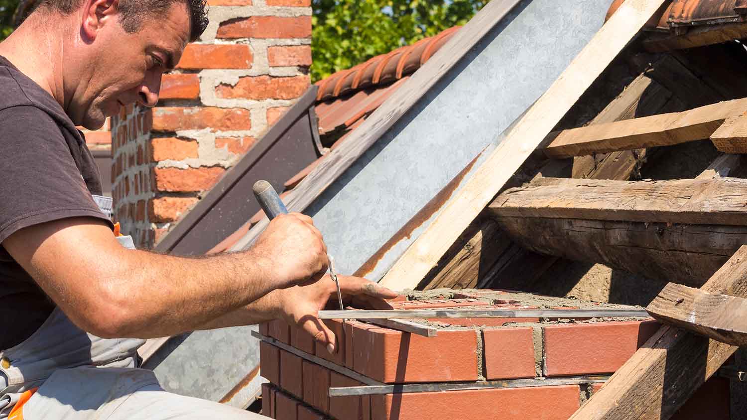 Mason repairing a brick chimney