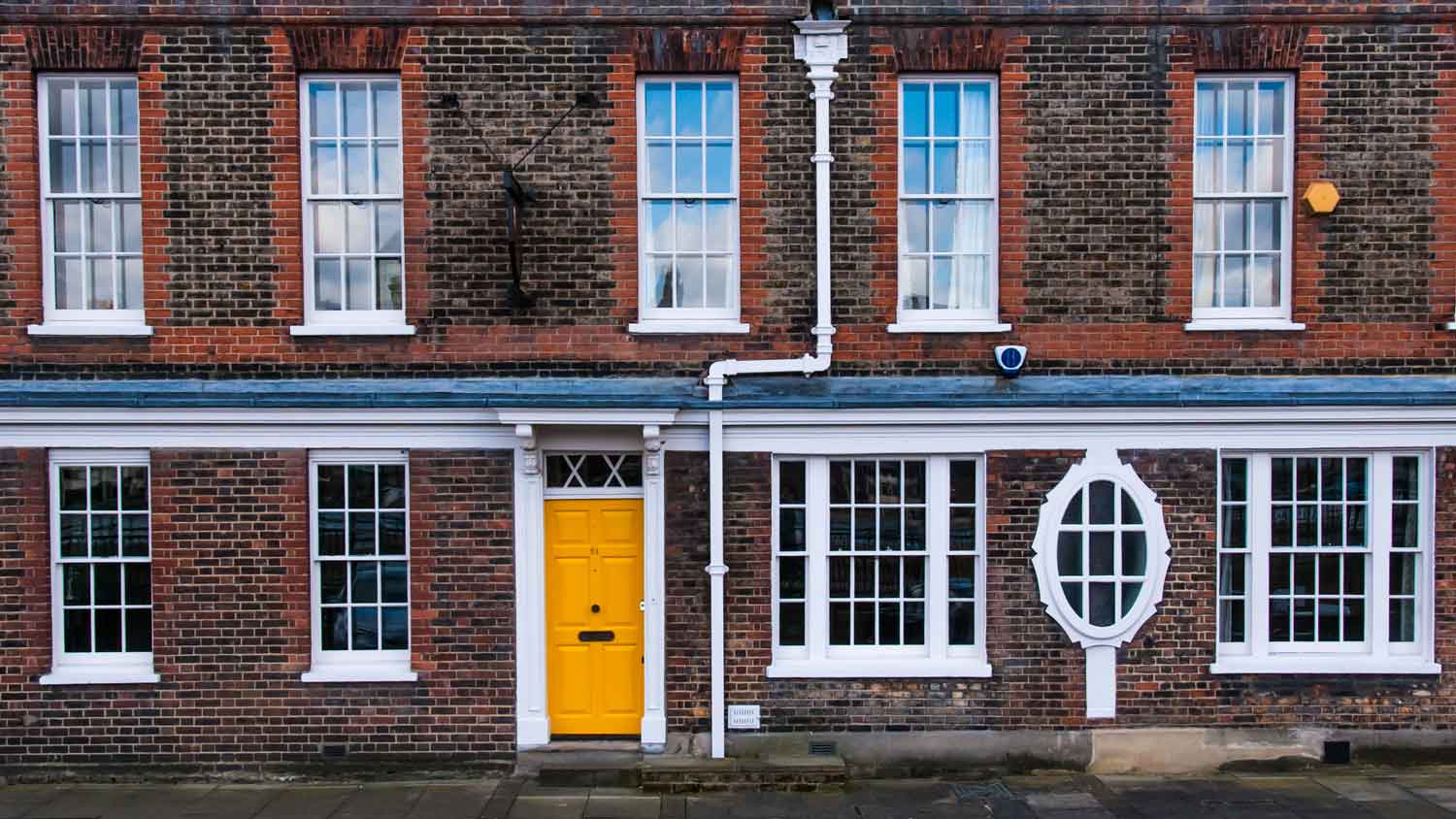 A brick house with a bright yellow door