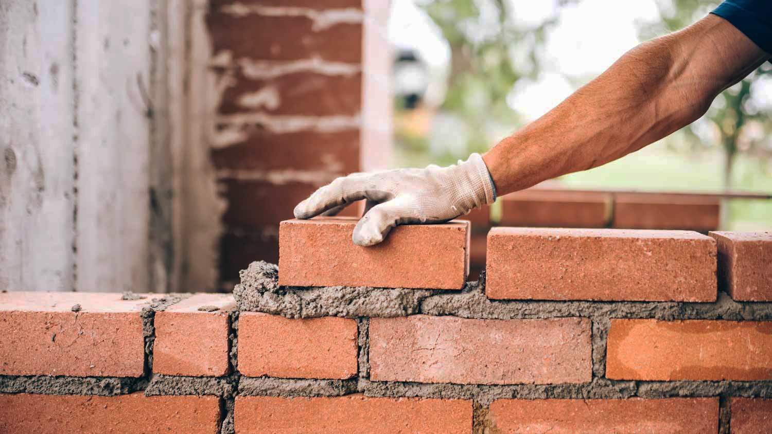 Worker placing brick for wall