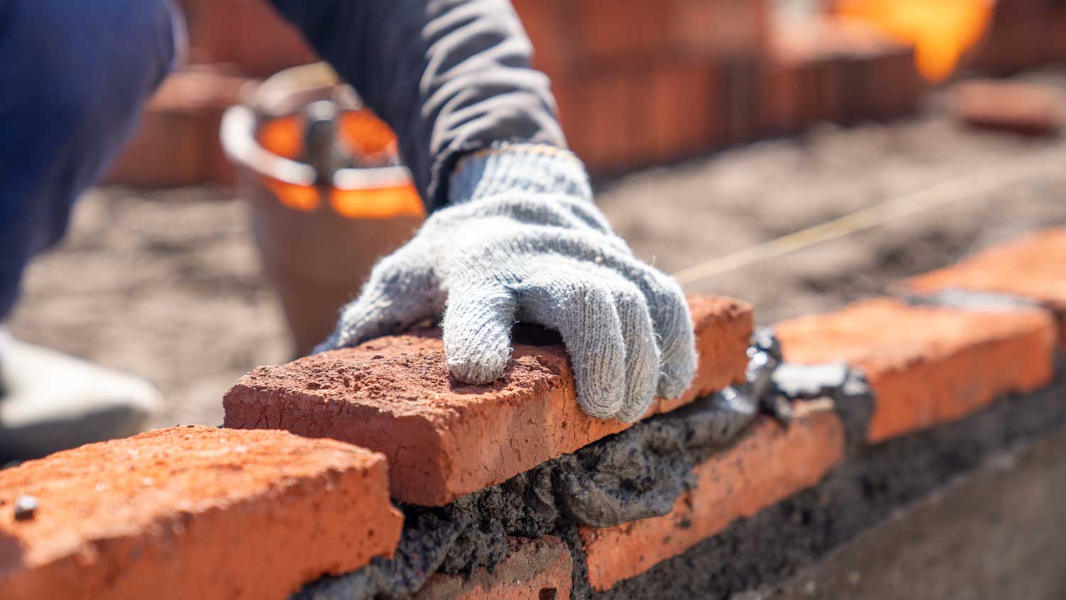  A builder applying mortar between bricks