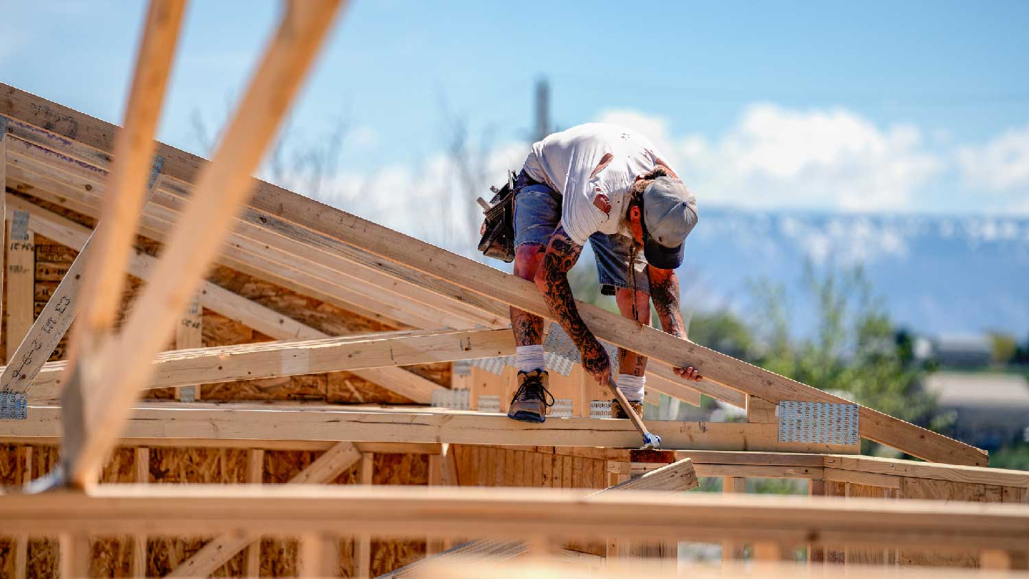 A builder working on the frame of the house