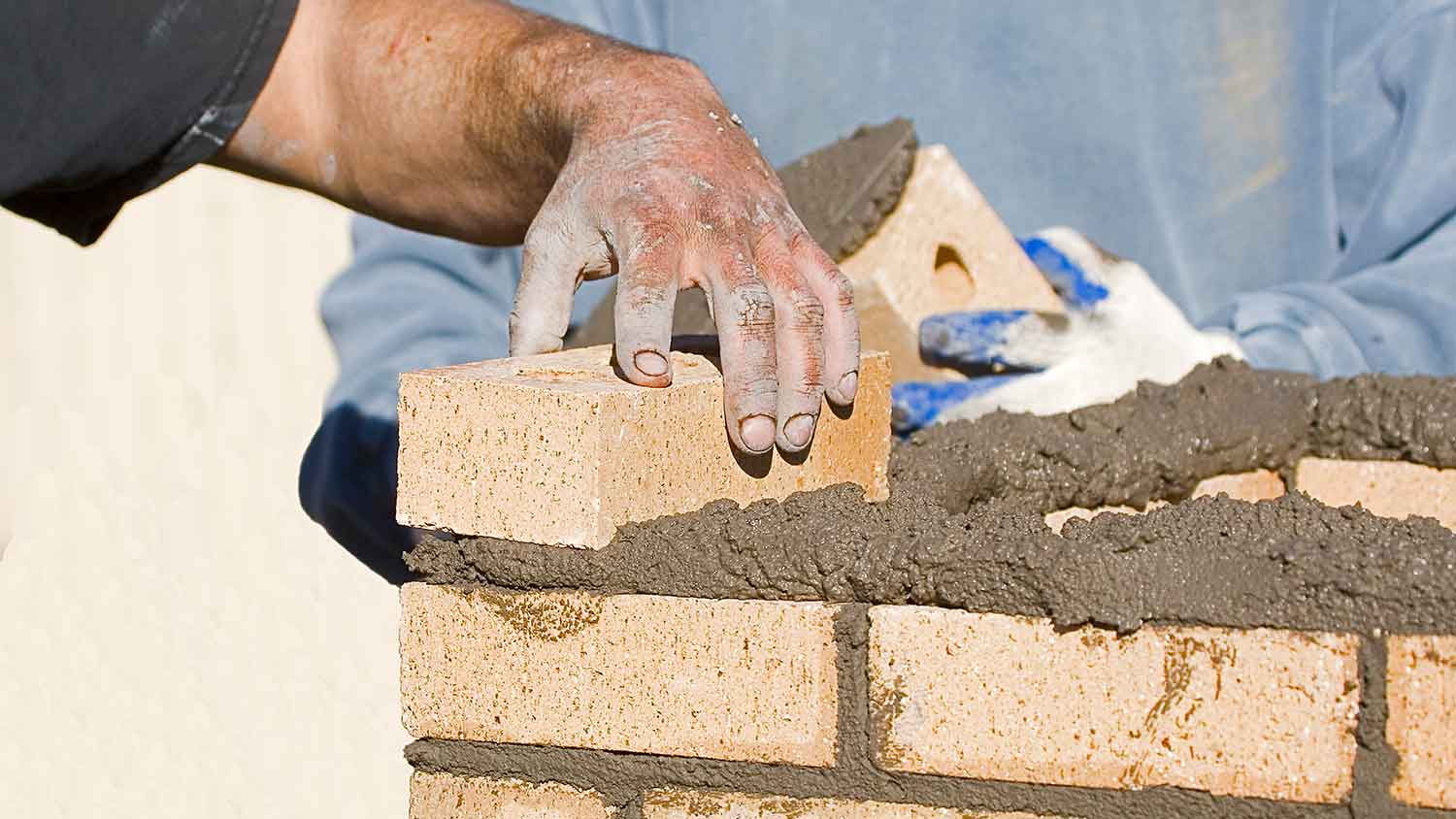 Workers building a brick mailbox