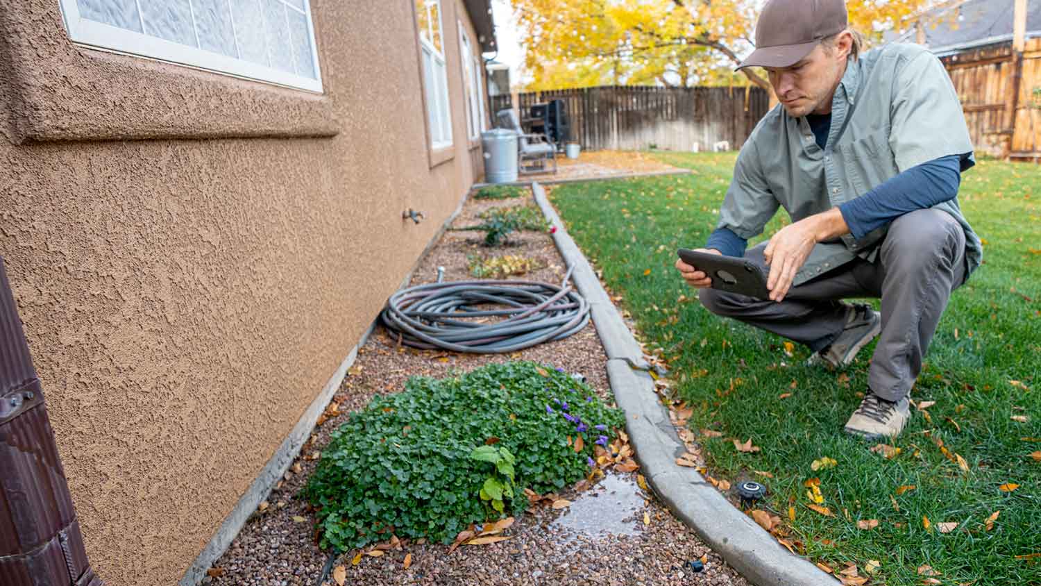 Inspector checking pooling water near the house foundation
