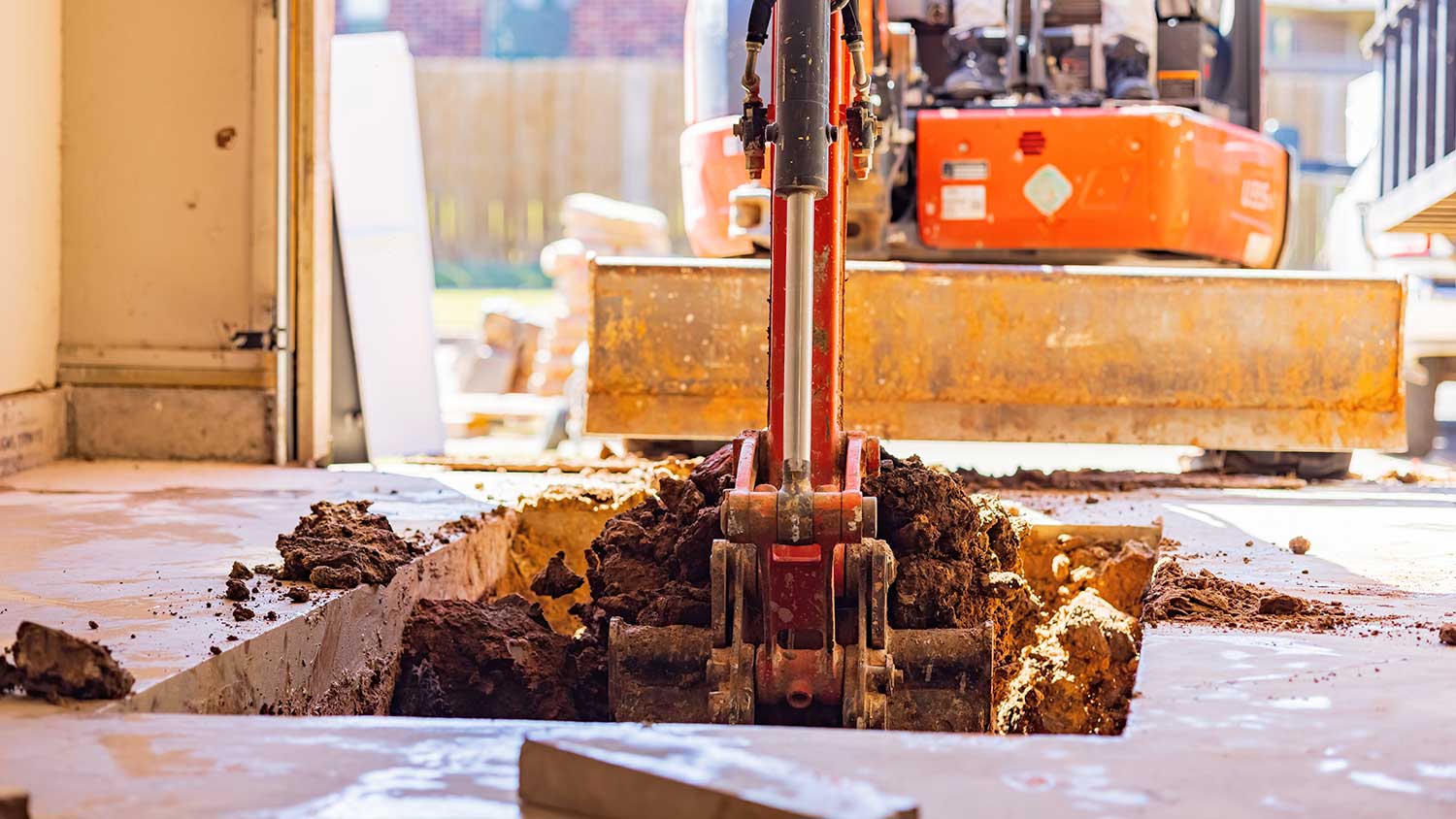 Worker using excavator to build underground shelter