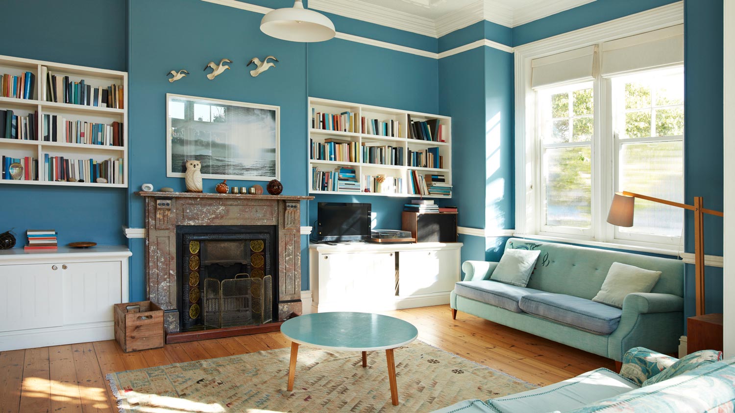 Built-in bookshelves in a blue painted living room