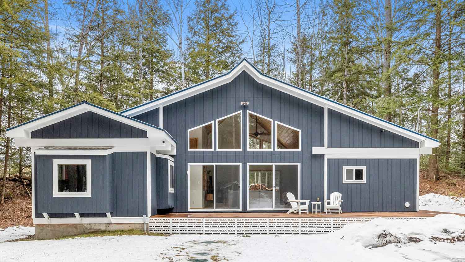 Cabin with blue vinyl siding and deck