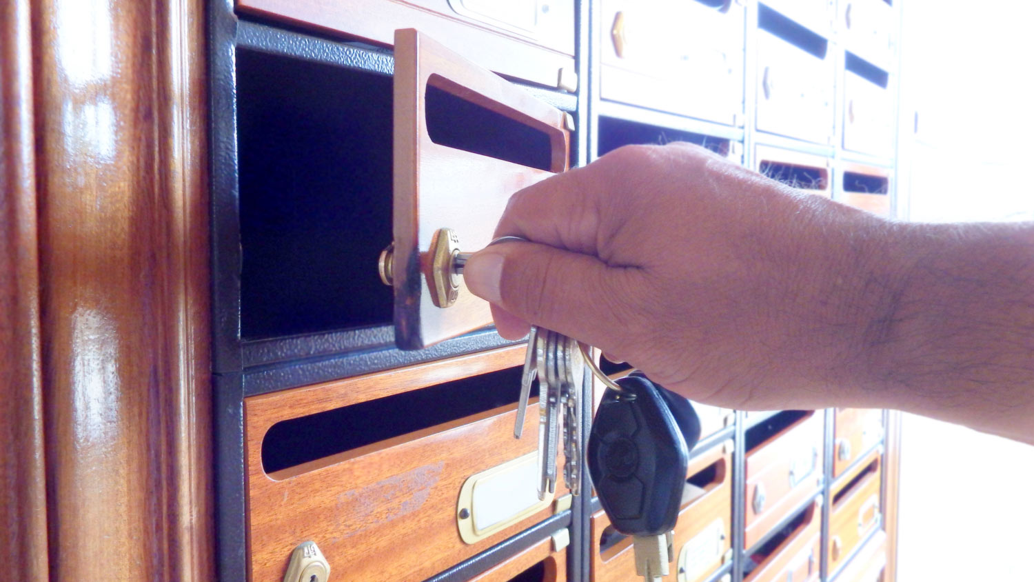 A man’s hand unlocking his mailbox