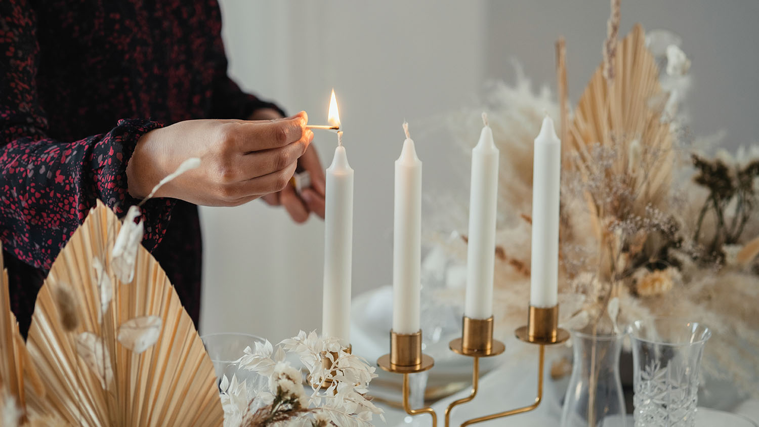 woman lighting candlesticks 