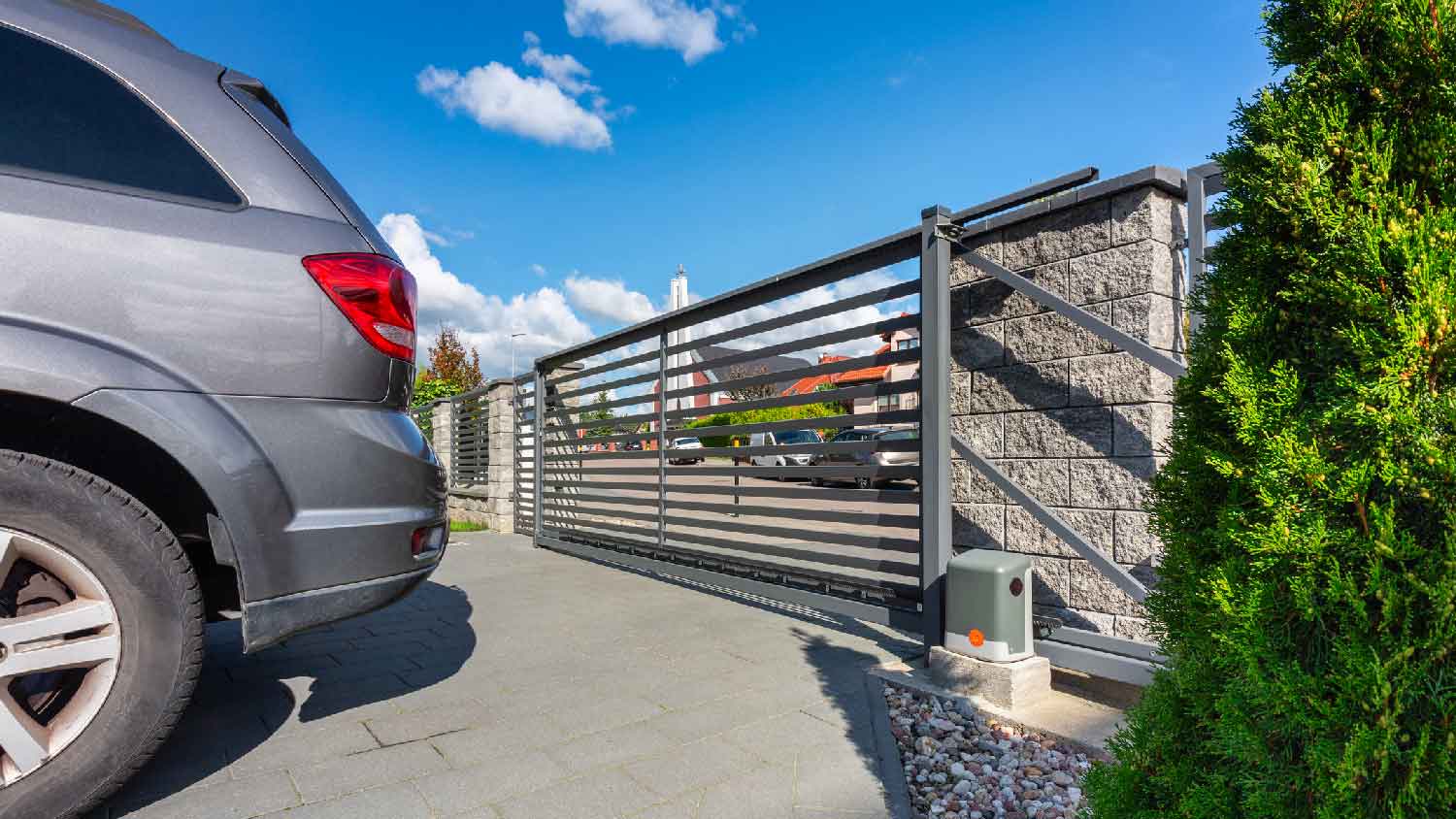 A car parked in a driveway with the gate closed