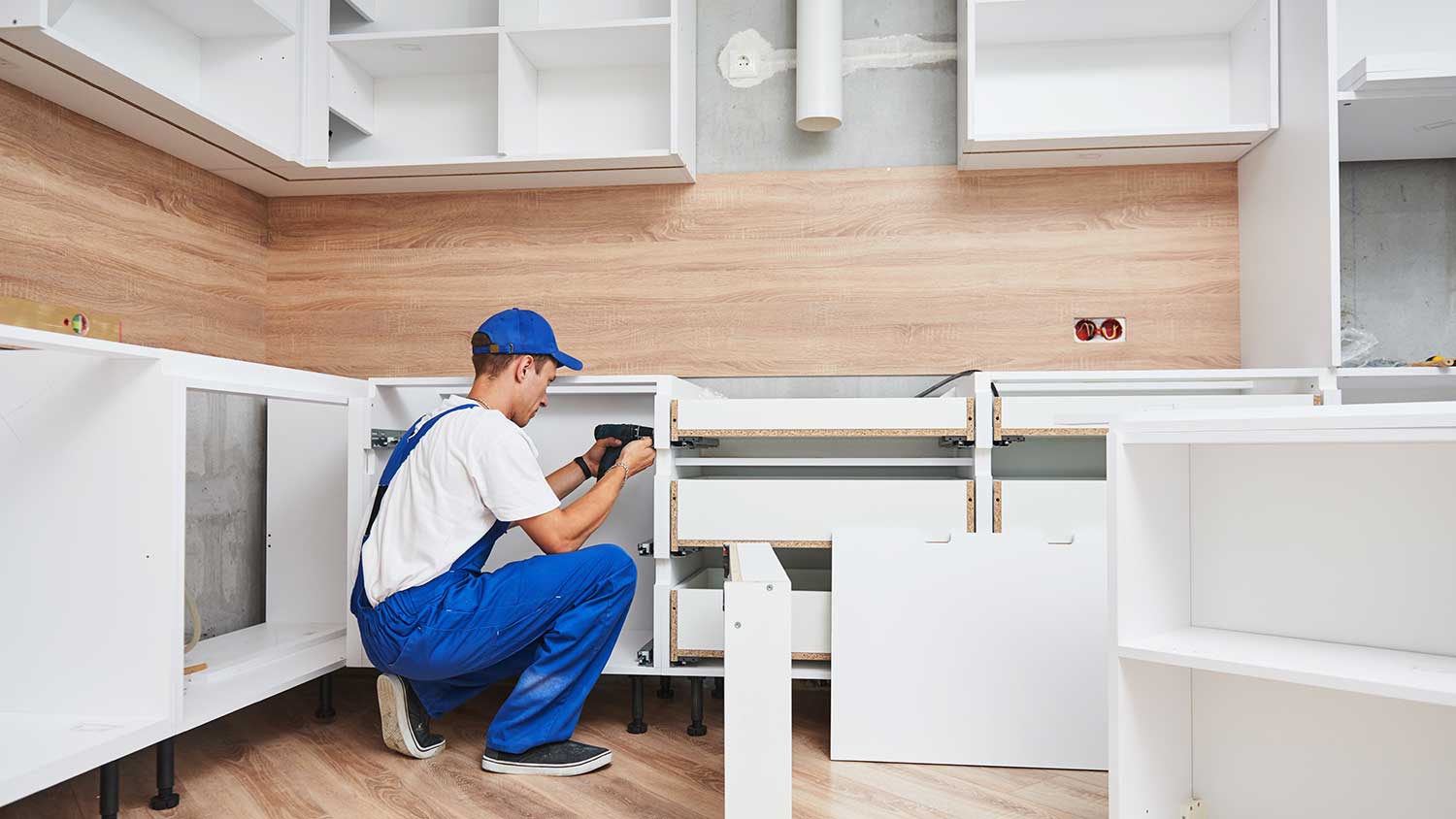  Carpenter assembling new kitchen cabinets