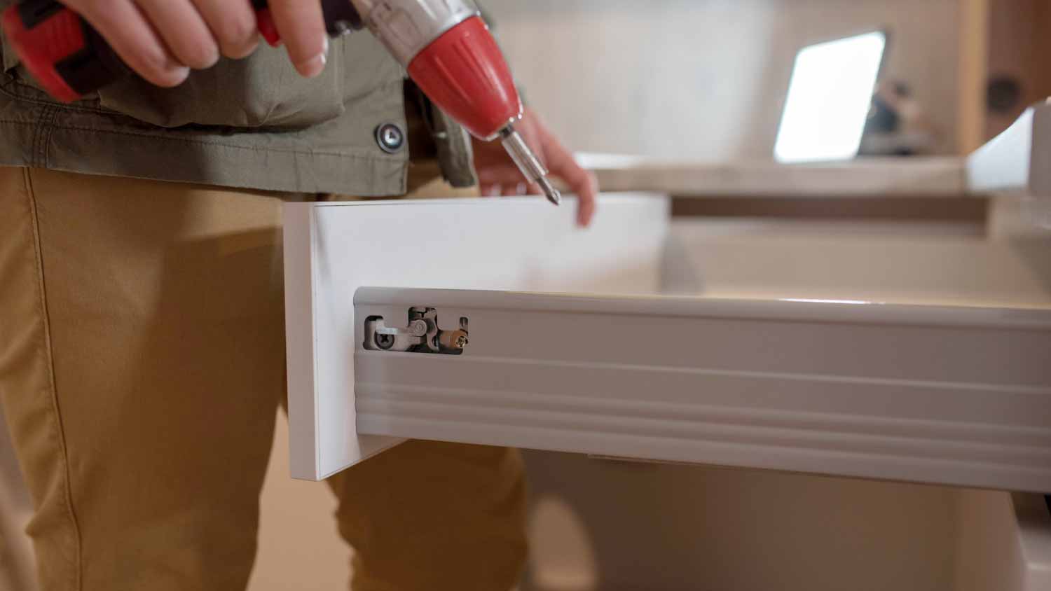 A carpenter installing a drawer