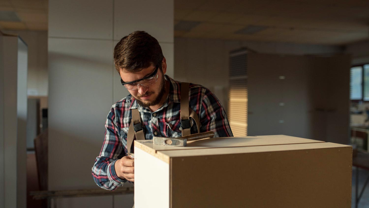 A carpenter installing new kitchen cabinets