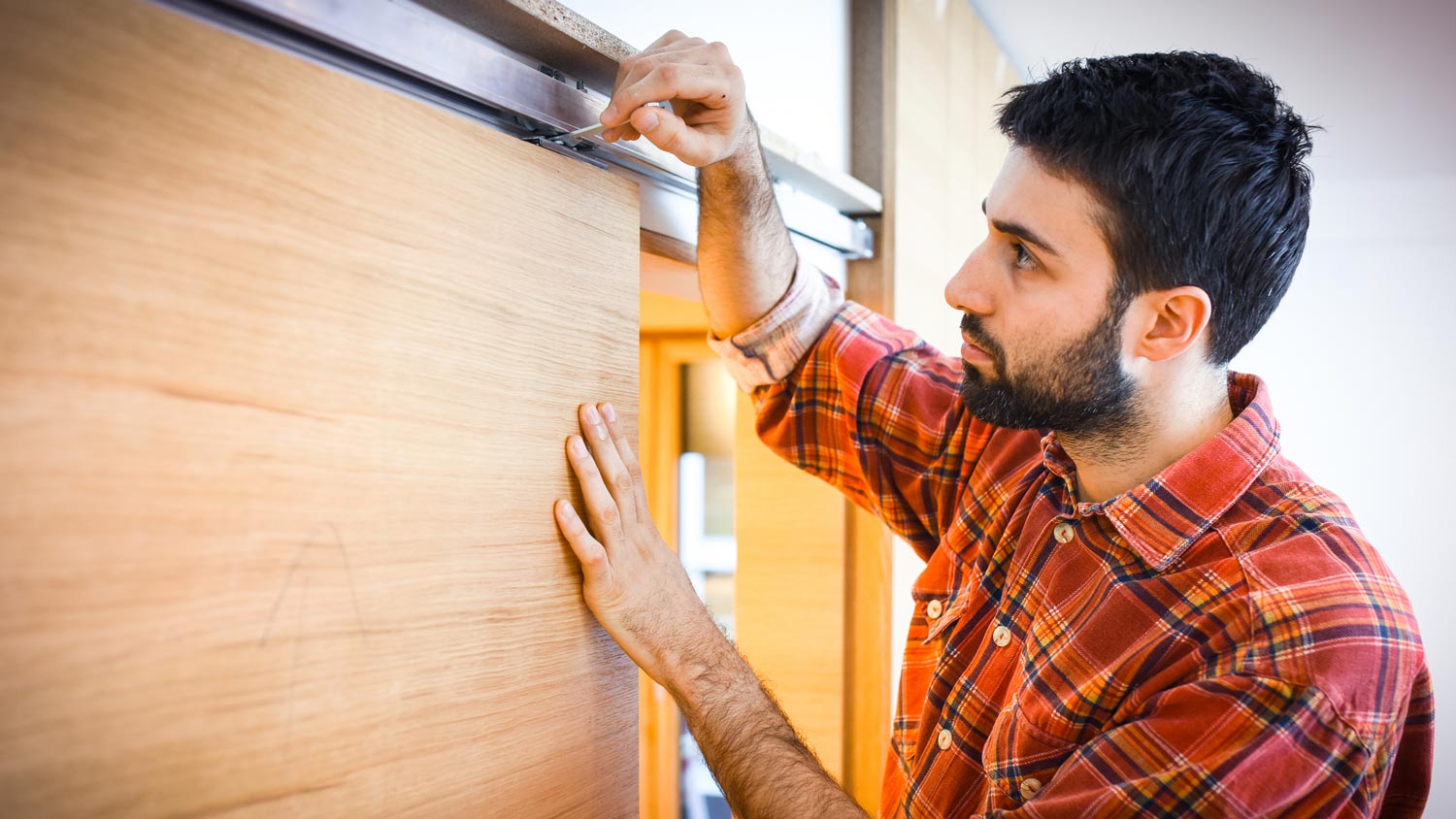 A carpenter installing a plywood sliding door