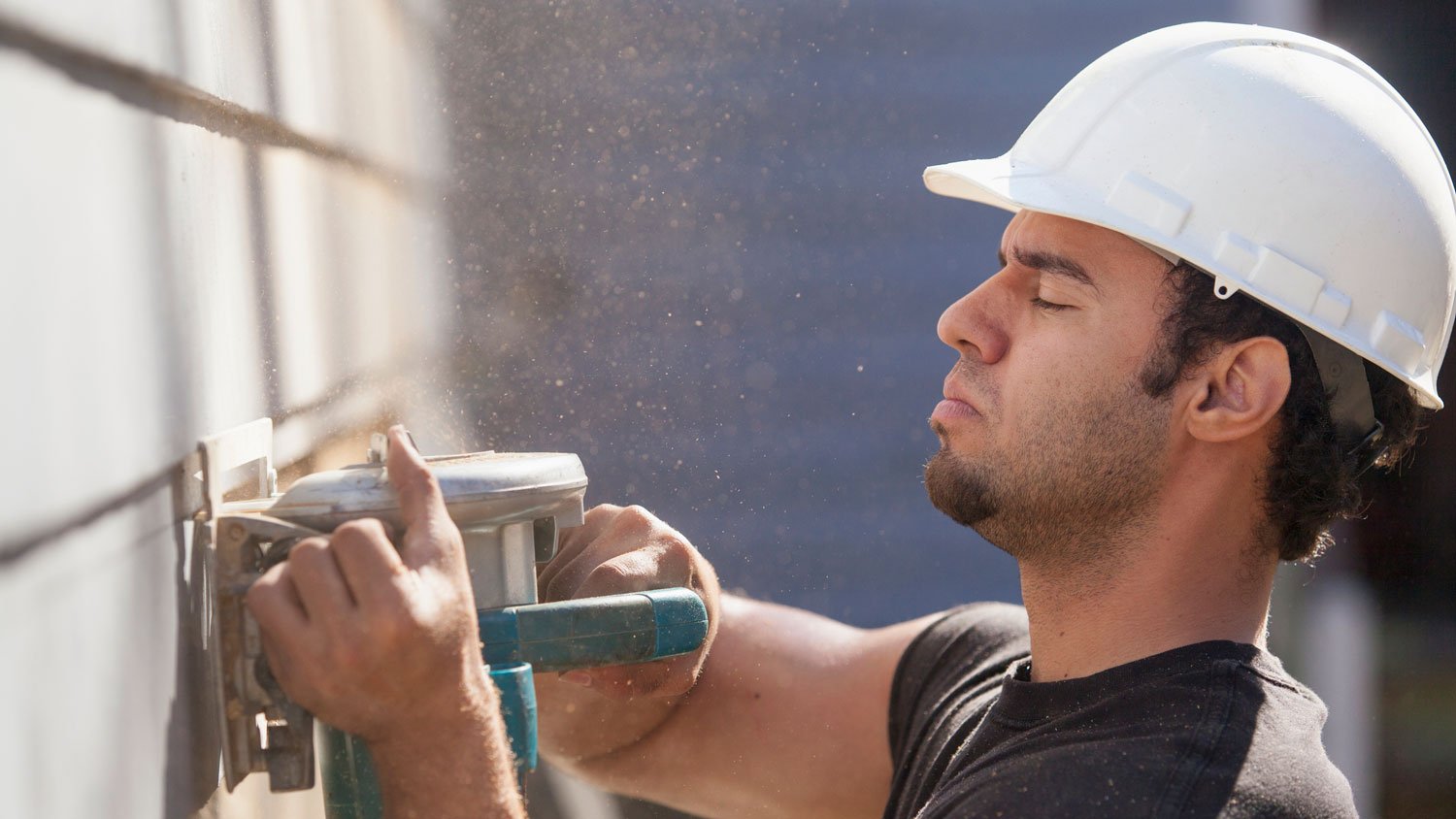 Carpenter repairing house siding