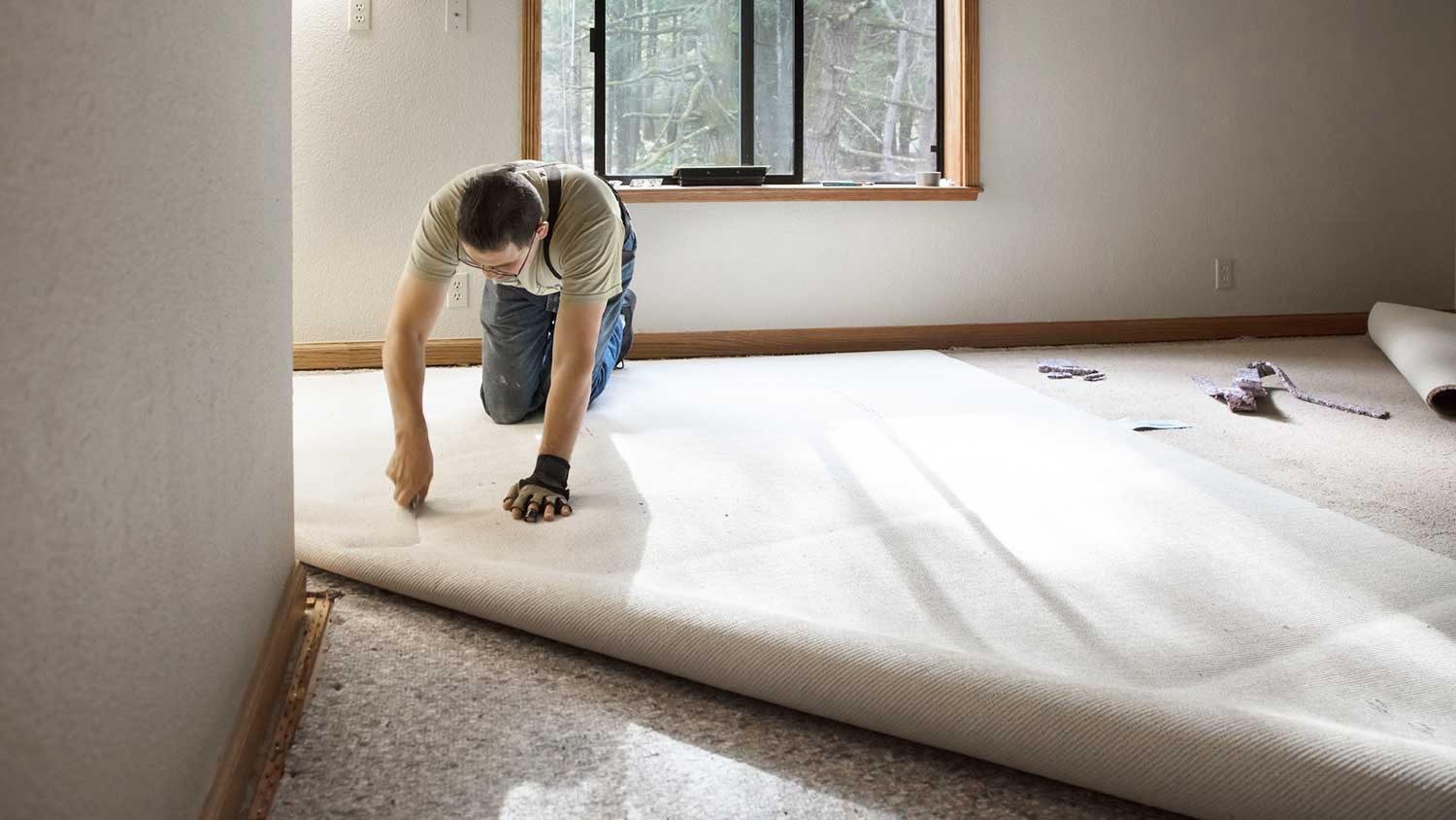 Contractor installing new carpet in the living room